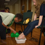 Eileen Schofield washes Kara Downey's feet. Photo by Brian A. Taylor Photography