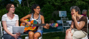 Housemates Kara Olenick, Crisely Melecio-Zambrano, and Deb Green put on an outdoor concert. Photo ©Brian A Taylor