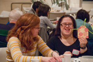 Laurie Pippenger (right) shows off an apron she made during a Lenten mini-retreat at Our Lady, Queen of Peace Church. Pippenger and Eva-Elizabeth Chisholm (left) are both members of L’Arche, an interdenominational Christian community that includes individuals with intellectual disabilities. Katie Scott | Catholic Herald